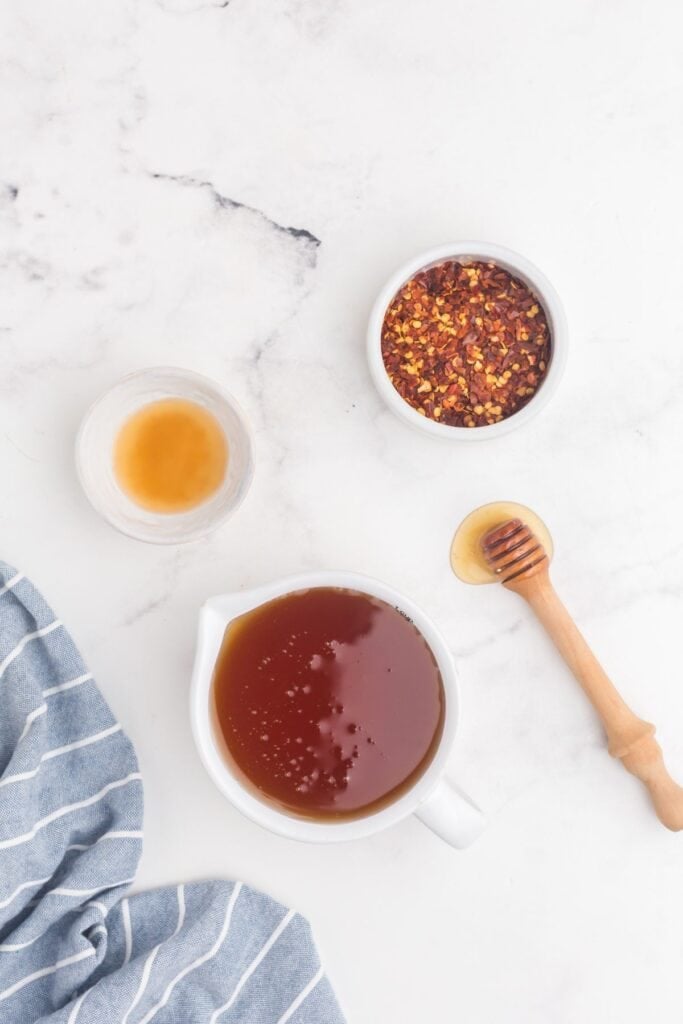 Ingredients for hot honey sauce: honey, red pepper flakes, and apple cider vinegar.