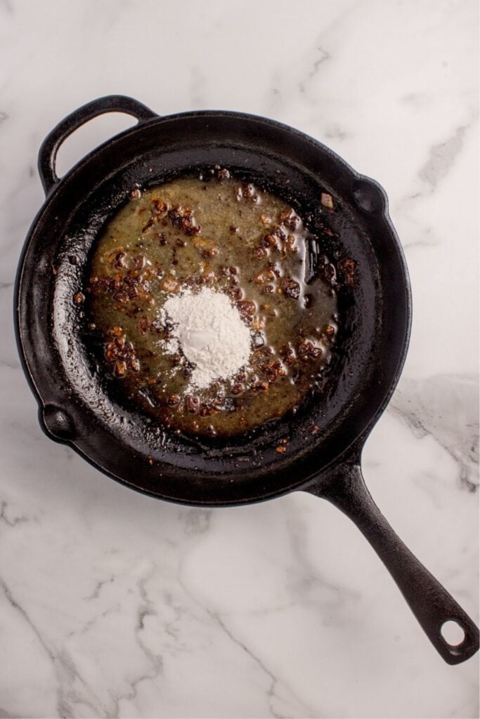 Flour added to cast iron pan to create a roux.