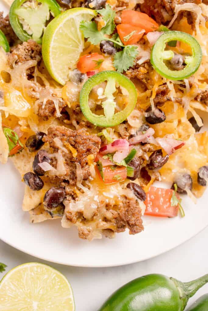 Oven nachos on a white dinner plate.
