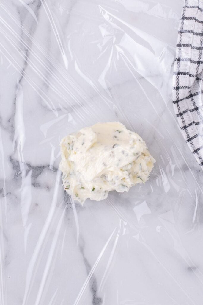 Plastic saran wrap with compound butter in the center.