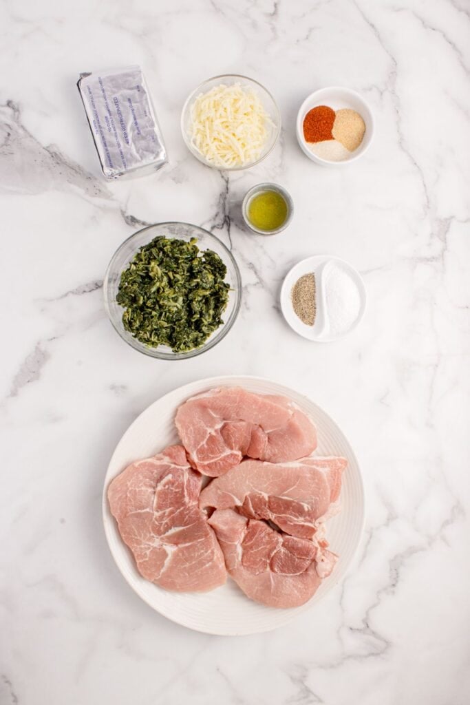 Ingredients for stuffed pork chops: cream cheese, mozzarella cheese, frozen spinach, salt, black pepper, onion powder, garlic powder, paprika, and oil.