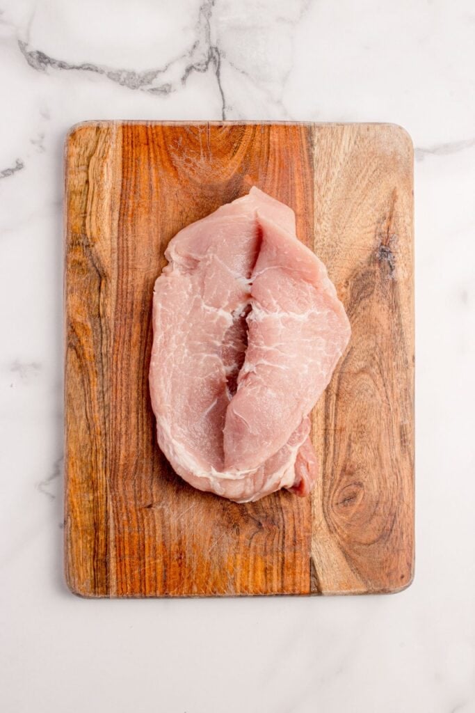 Pork chop sliced open lengthwise and folded upon itself.