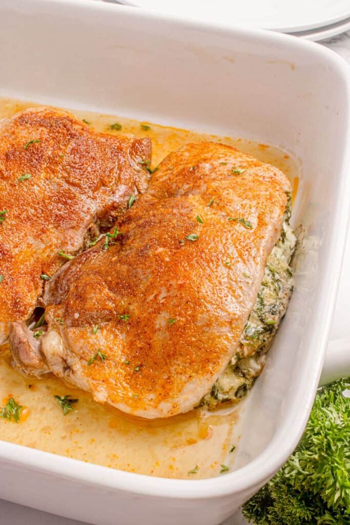 Completed pork chops in a white baking dish.