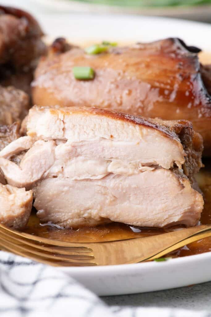 A chicken thigh is sliced in half to show the interior.