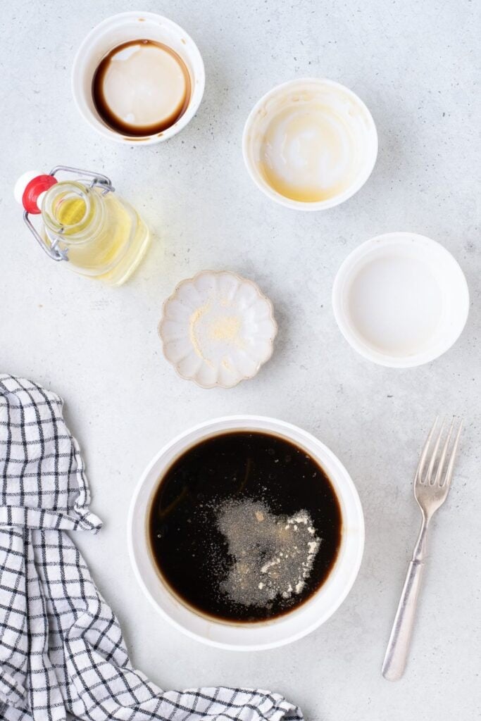 Soy sauce, honey, chicken broth, vegetable oil, and garlic powder are combined to create marinade for chicken thighs.