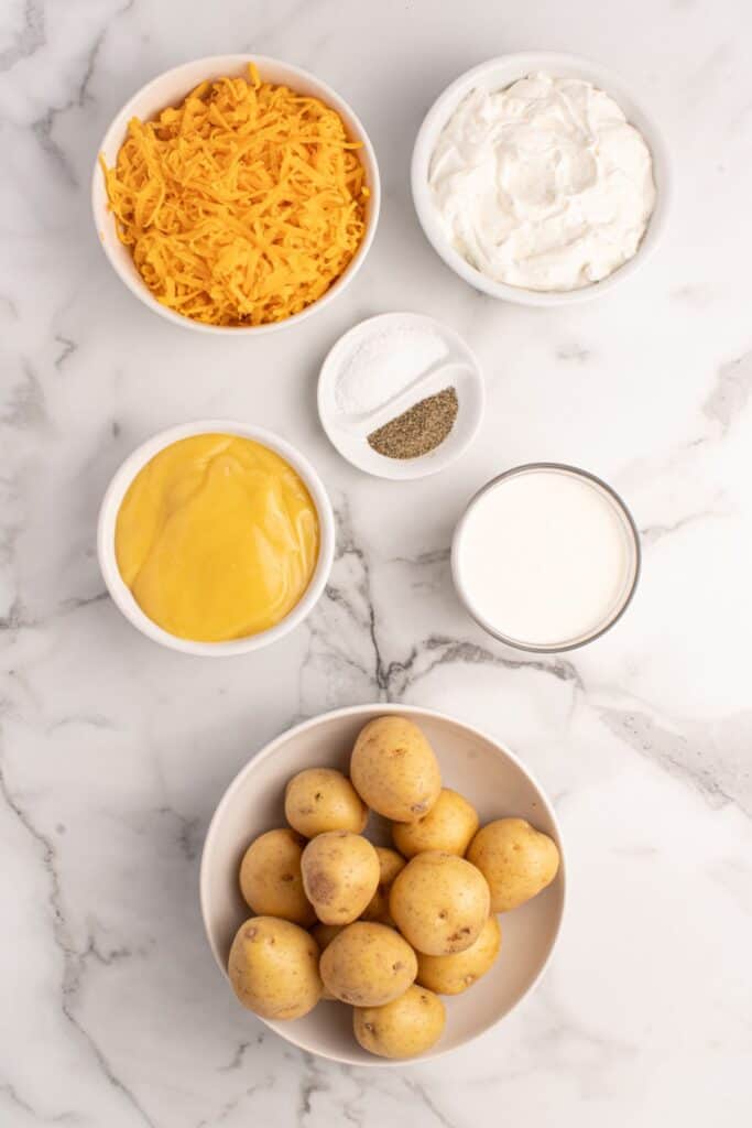 Ingredients for crockpot scalloped potatoes: Yukon Gold potatoes, heavy cream, cream of chicken soup, French onion dip, and cheddar cheese.