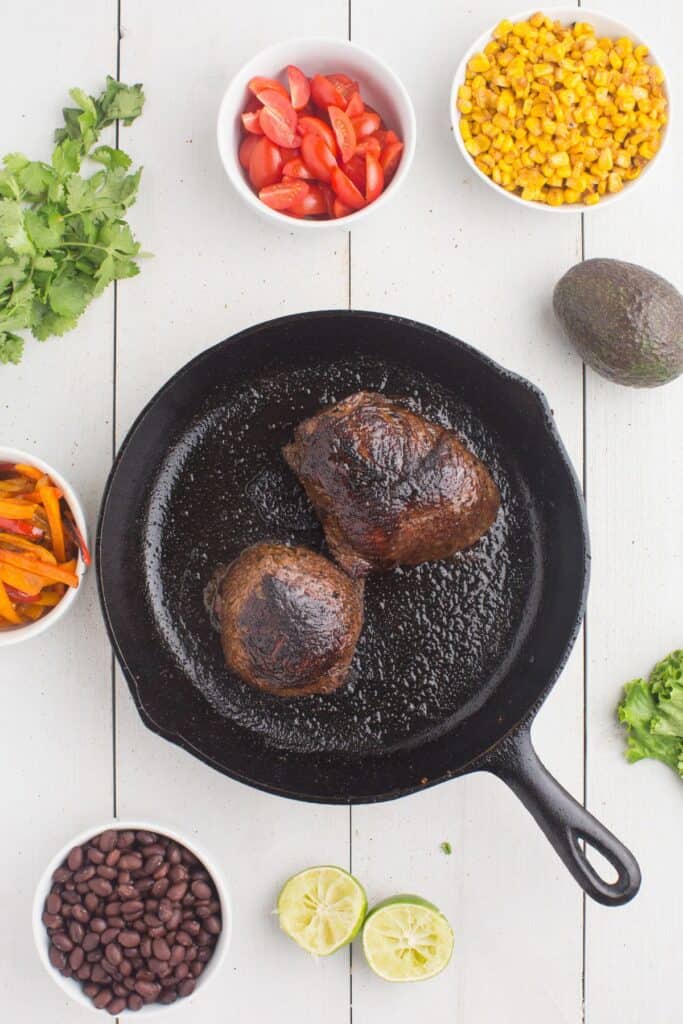 Cooked steak in a cast iron pan.