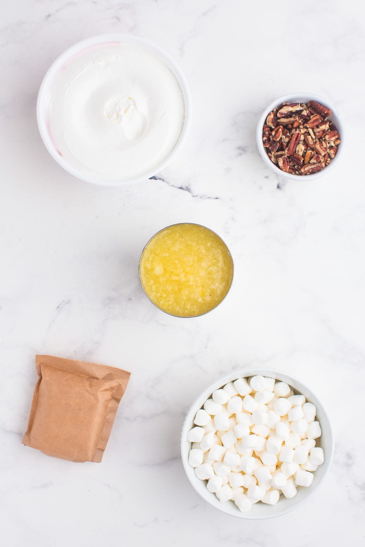 Ingredients for pineapple fluff: Crushed pineapple, vanilla pudding, mini marshmallows, crushed pecans, and Cool Whip.