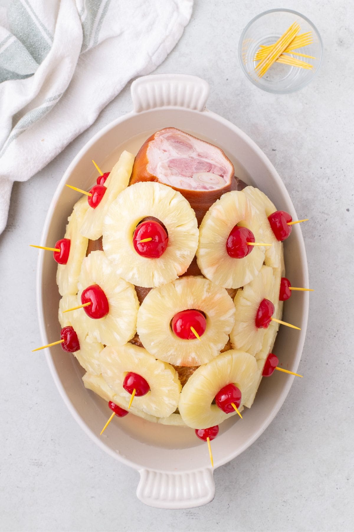 Ham has been decorated with cherries and pineapple rings all across the surface.