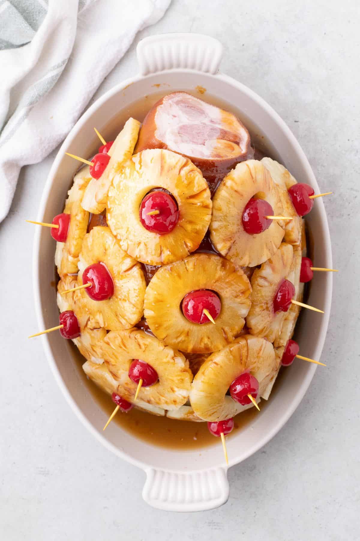 Uncooked, prepped ham with pineapple glaze poured over the top.