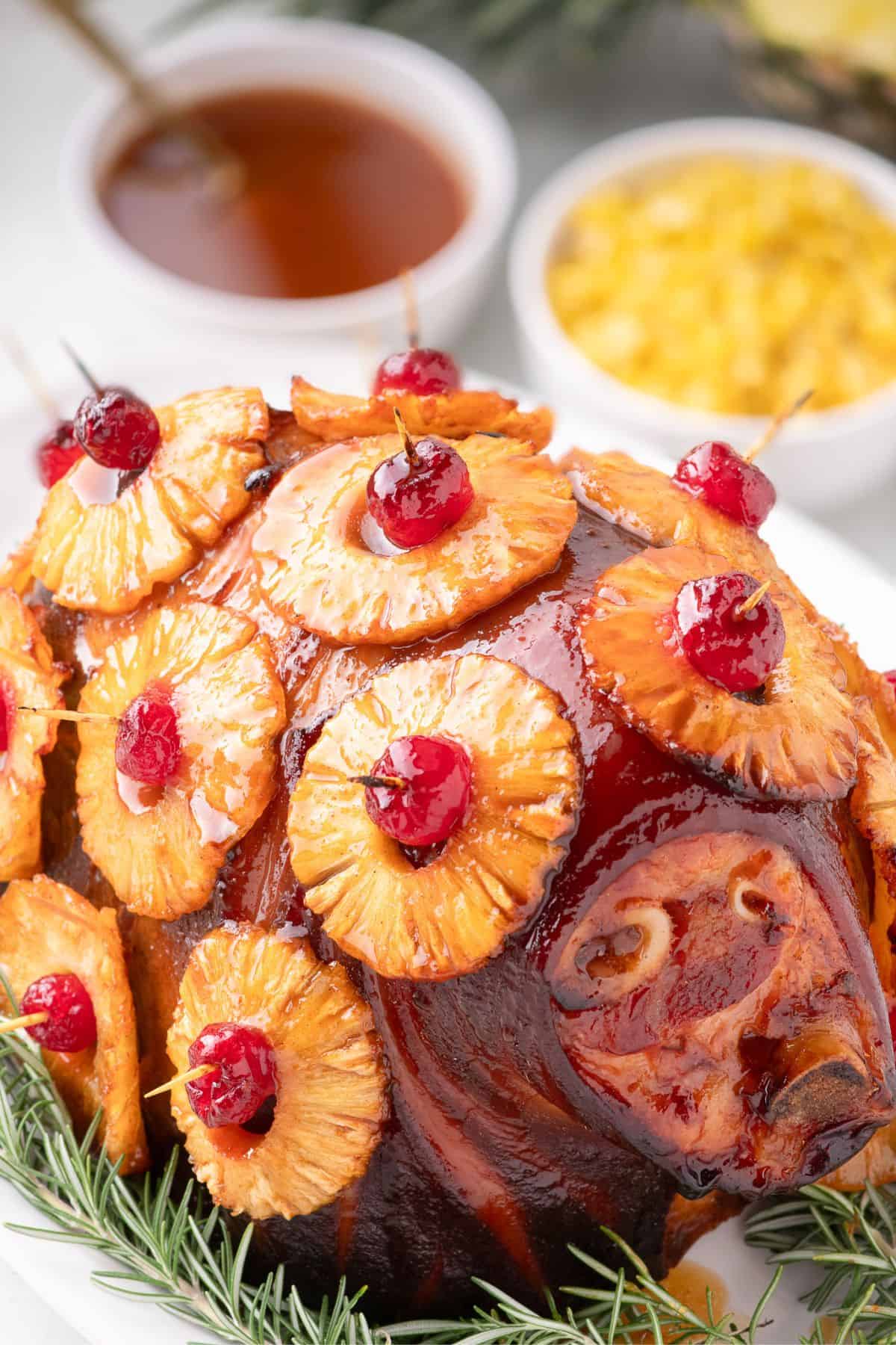 Completed pineapple glazed ham garnished with rosemary sprigs.