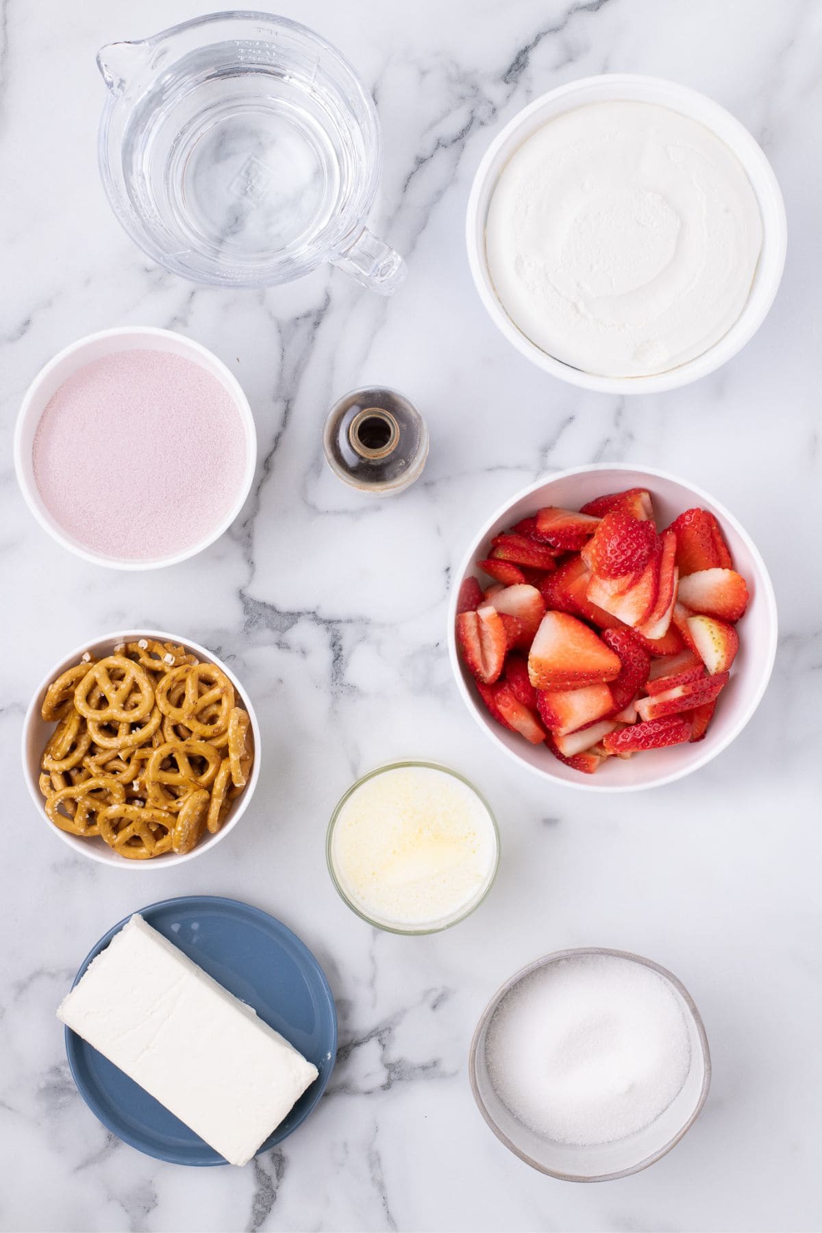 Ingredients for strawberry pretzel salad: Water, cool whip, strawberry Jello, sliced strawberries, pretzels, butter, sugar, and cream cheese.