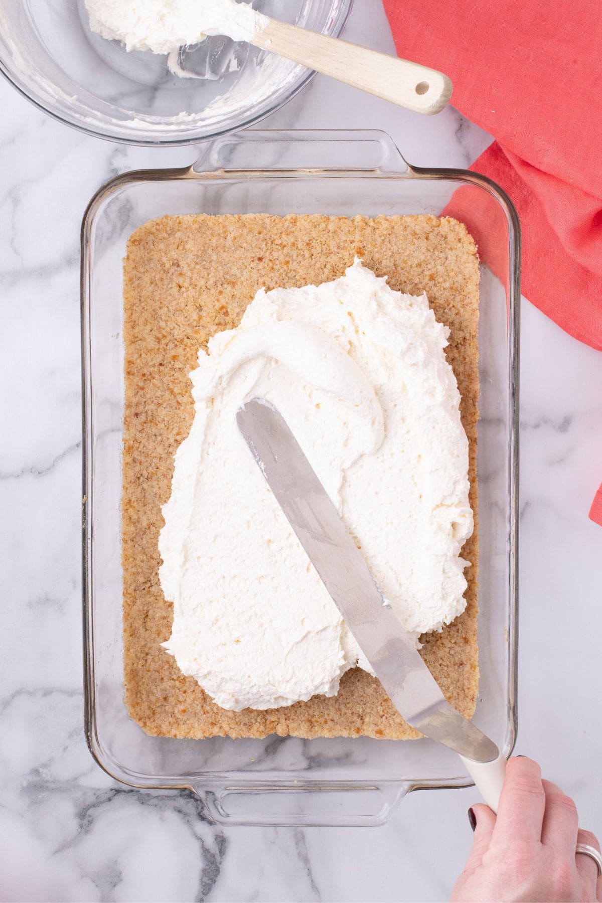 Cream cheese is spread onto the top of the baked pretzel layer.