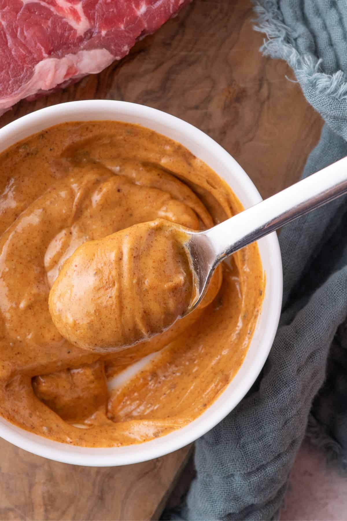Cowboy butter in a white bowl with a spoon lifting a serving above the bowl.