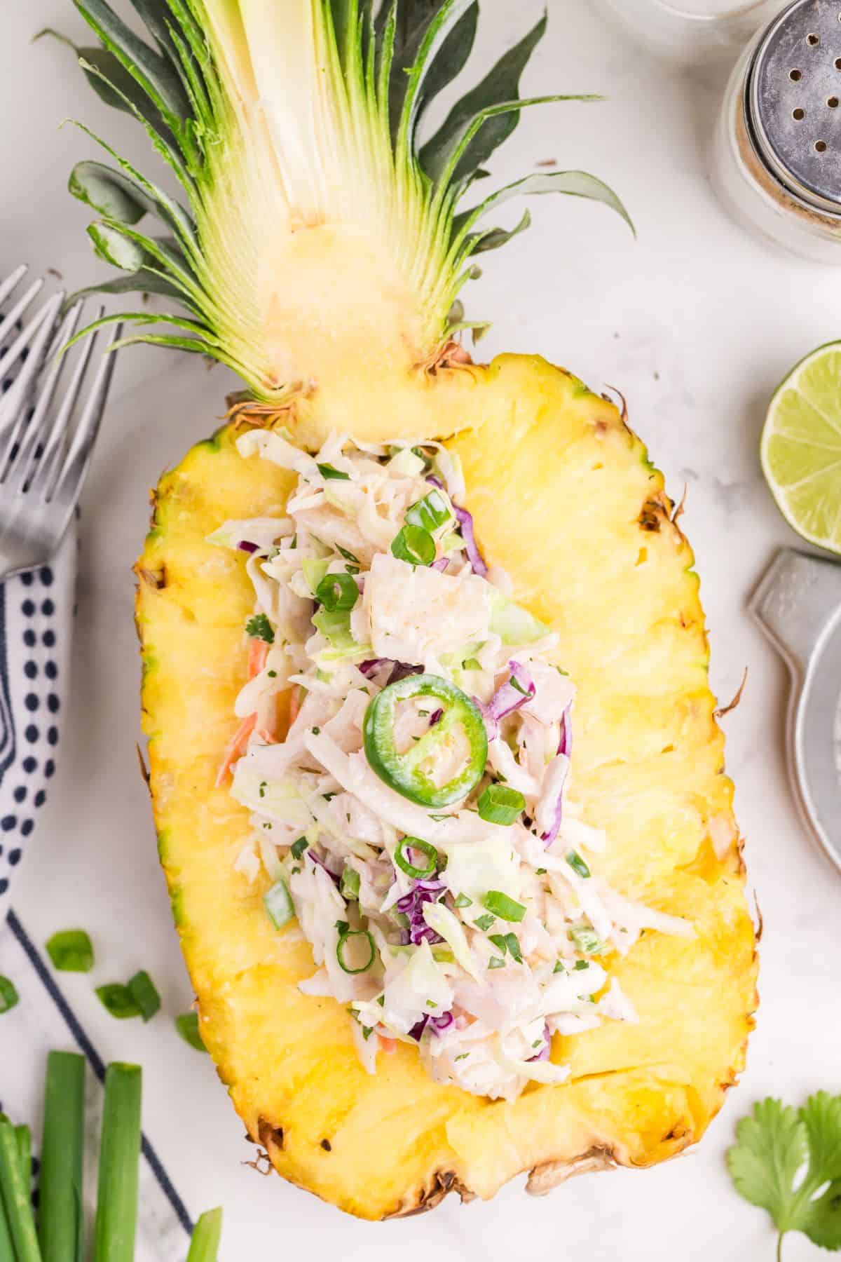 Pineapple coleslaw served in half a pineapple.