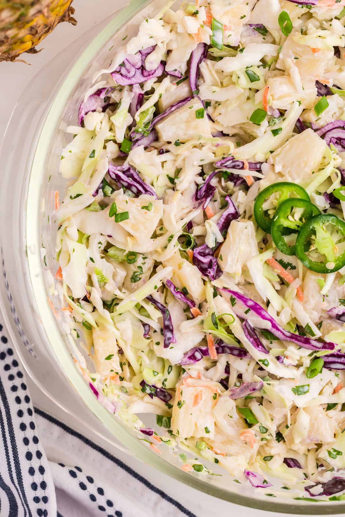 Pineapple coleslaw in a glass serving bowl.