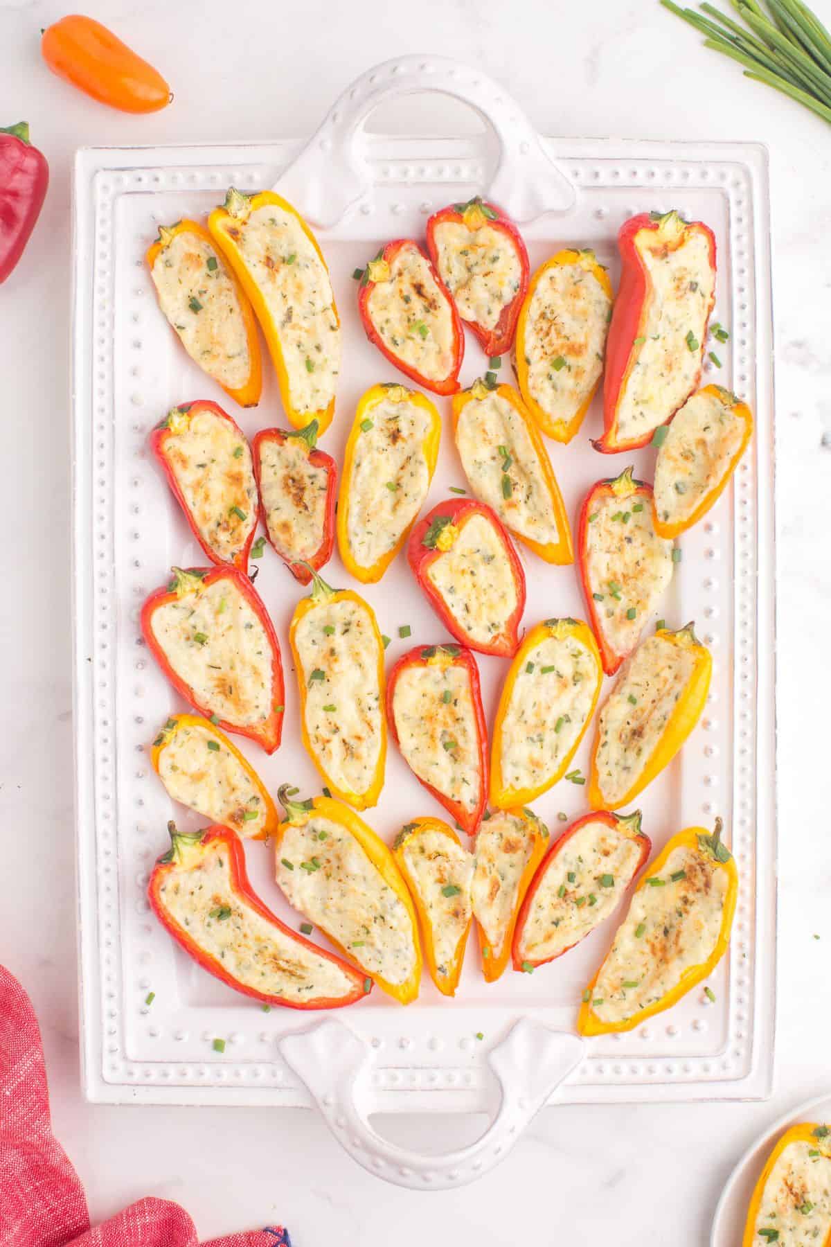 Baked cream cheese stuffed peppers on a serving platter.