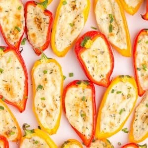 Overhead view of cream cheese stuffed peppers on a table covering the whole image.