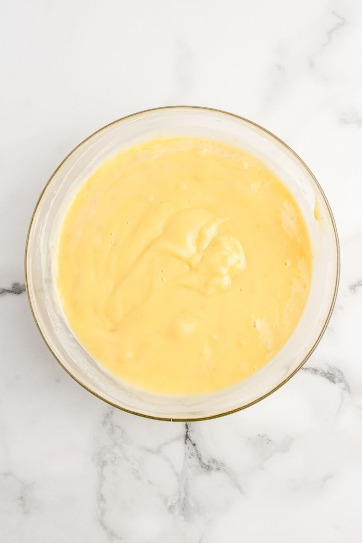 A glass mixing bowl with the cream of soup mixture.