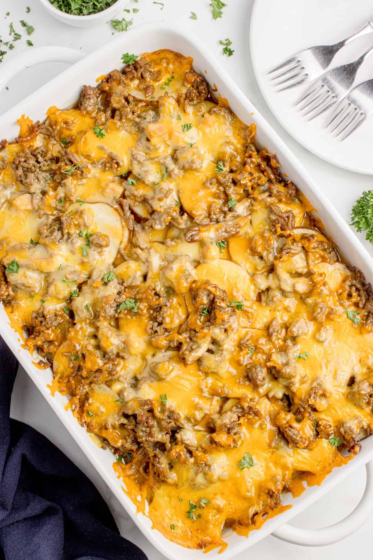 Completed Cheesy hamburger potato casserole in a white baking dish.