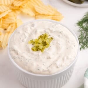 Completed dill pickle dip in a white ramekin.