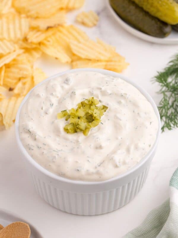 Completed dill pickle dip in a white ramekin.