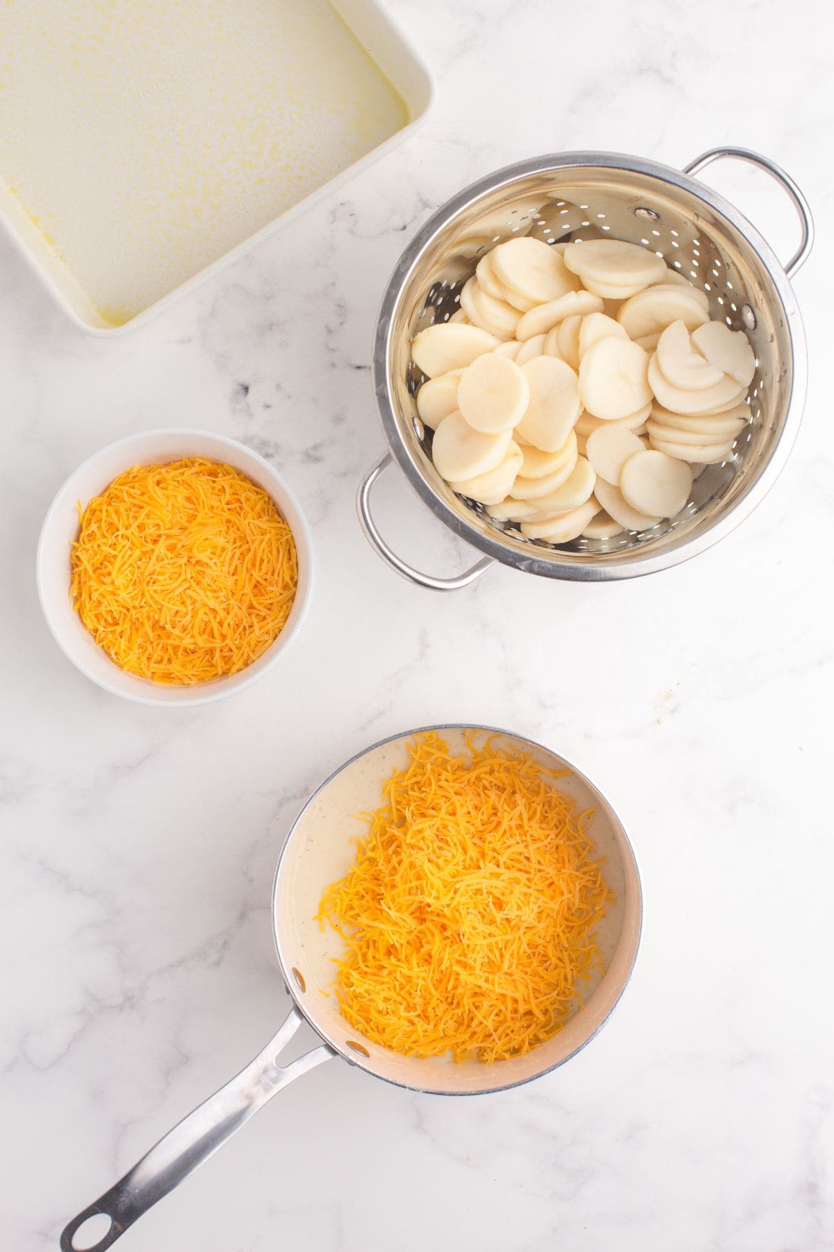 Shredded cheese added to the saucepan.