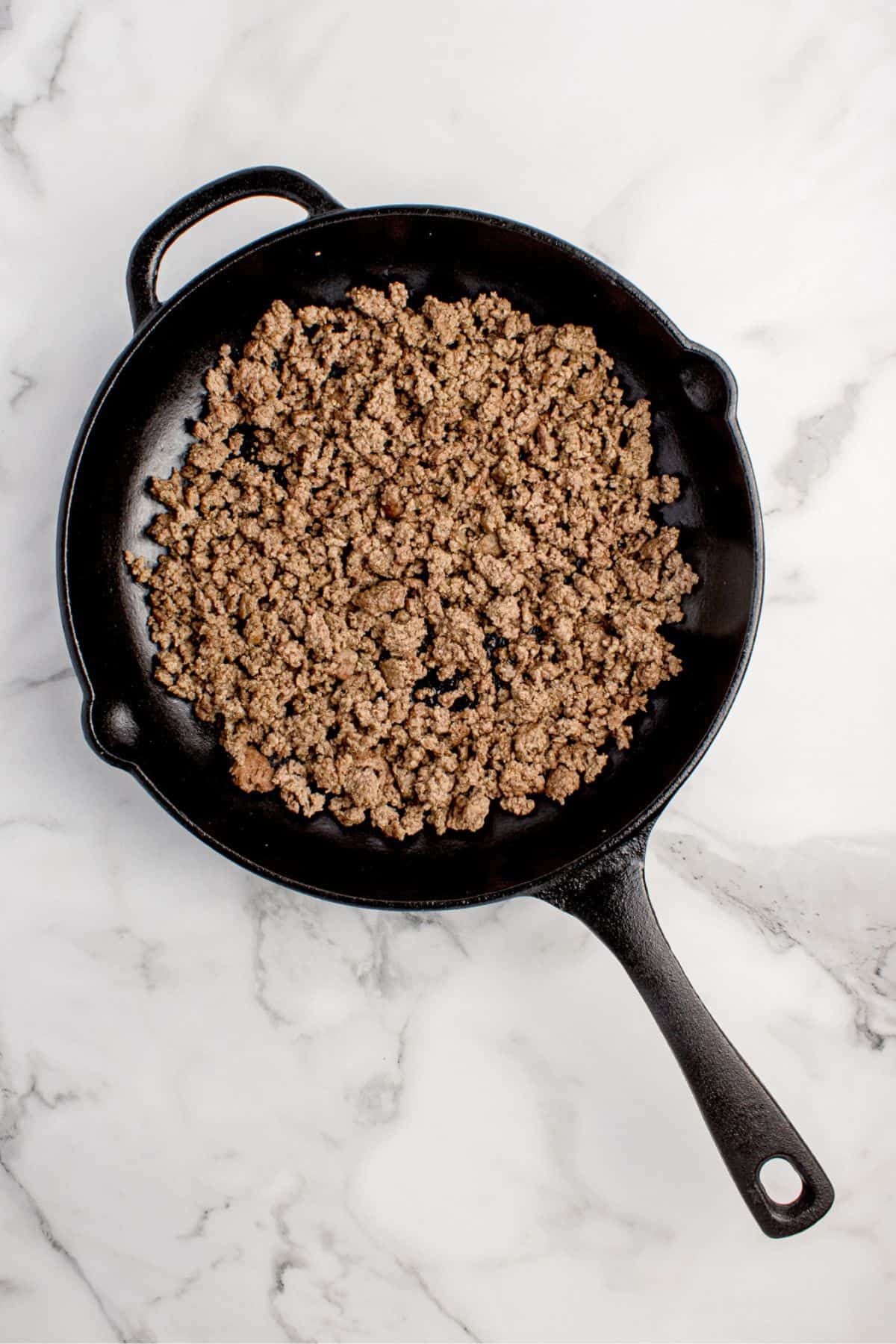 Cooked ground beef in a cast iron pan.