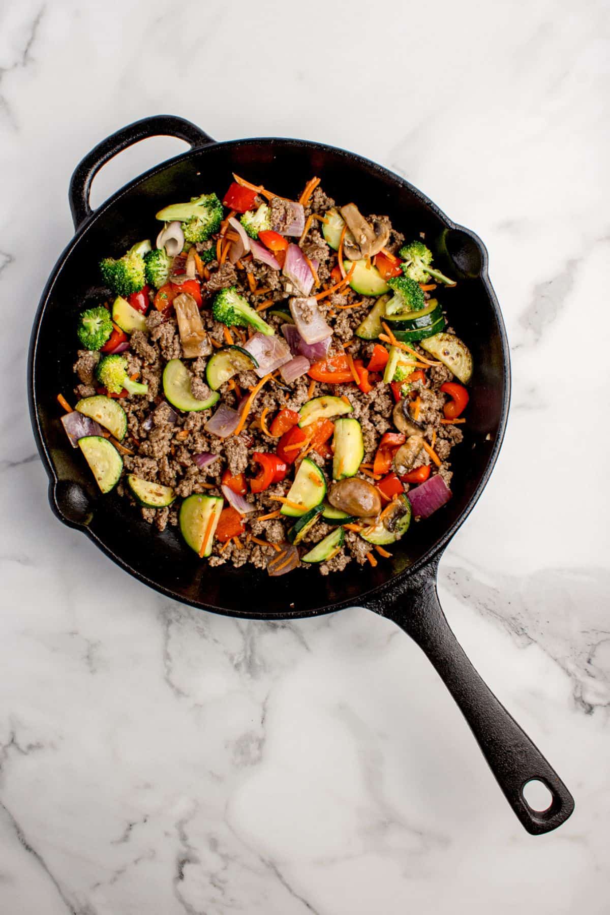 Ground beef added to cast iron pan with the veggies.