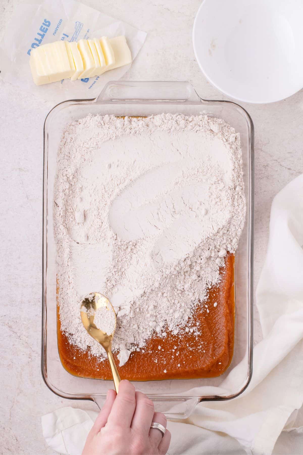 Cake mix is evenly spread over the top of the pumpkin pie filling.
