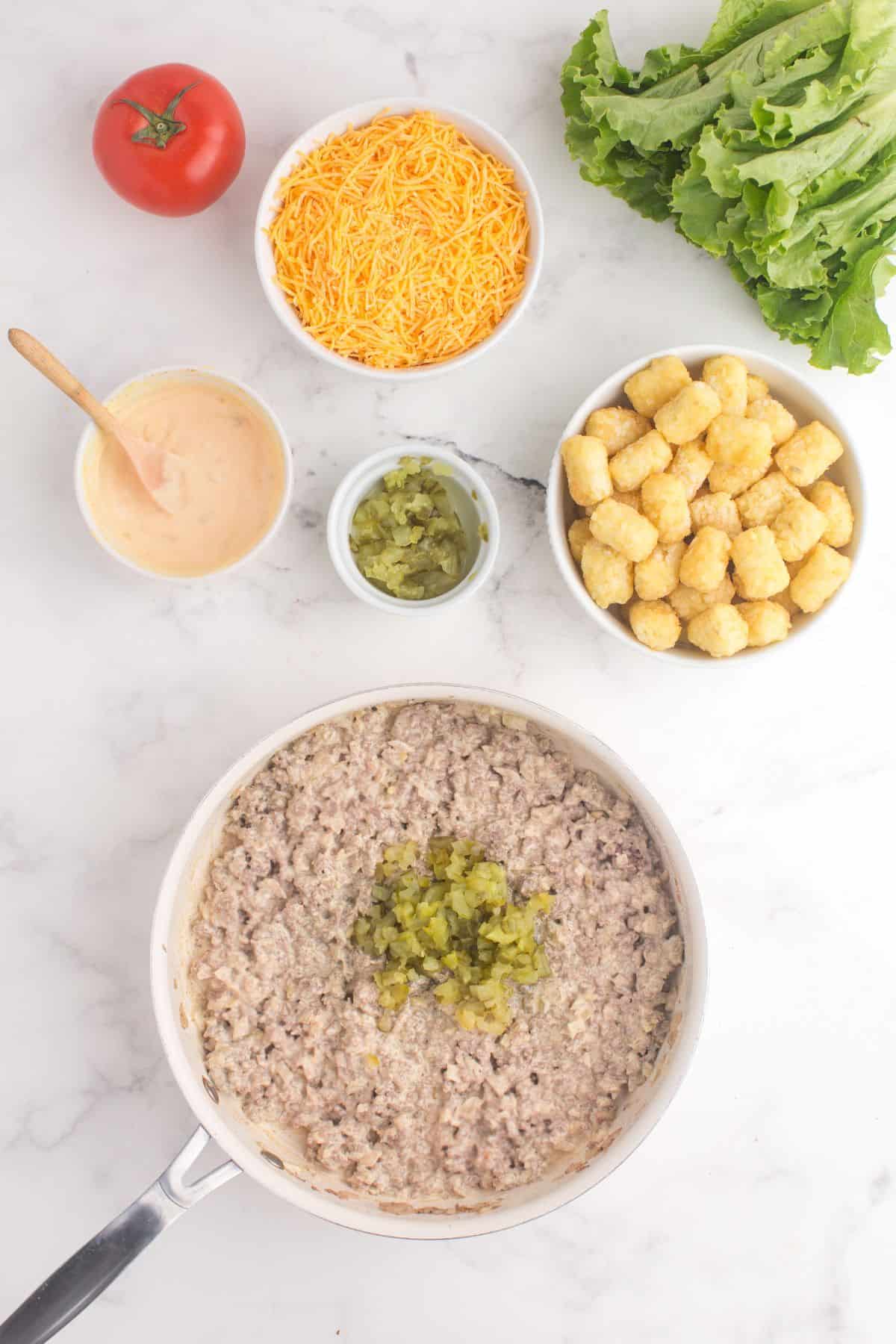 Add big mac sauce and pickles to the ground beef and onion mixture.