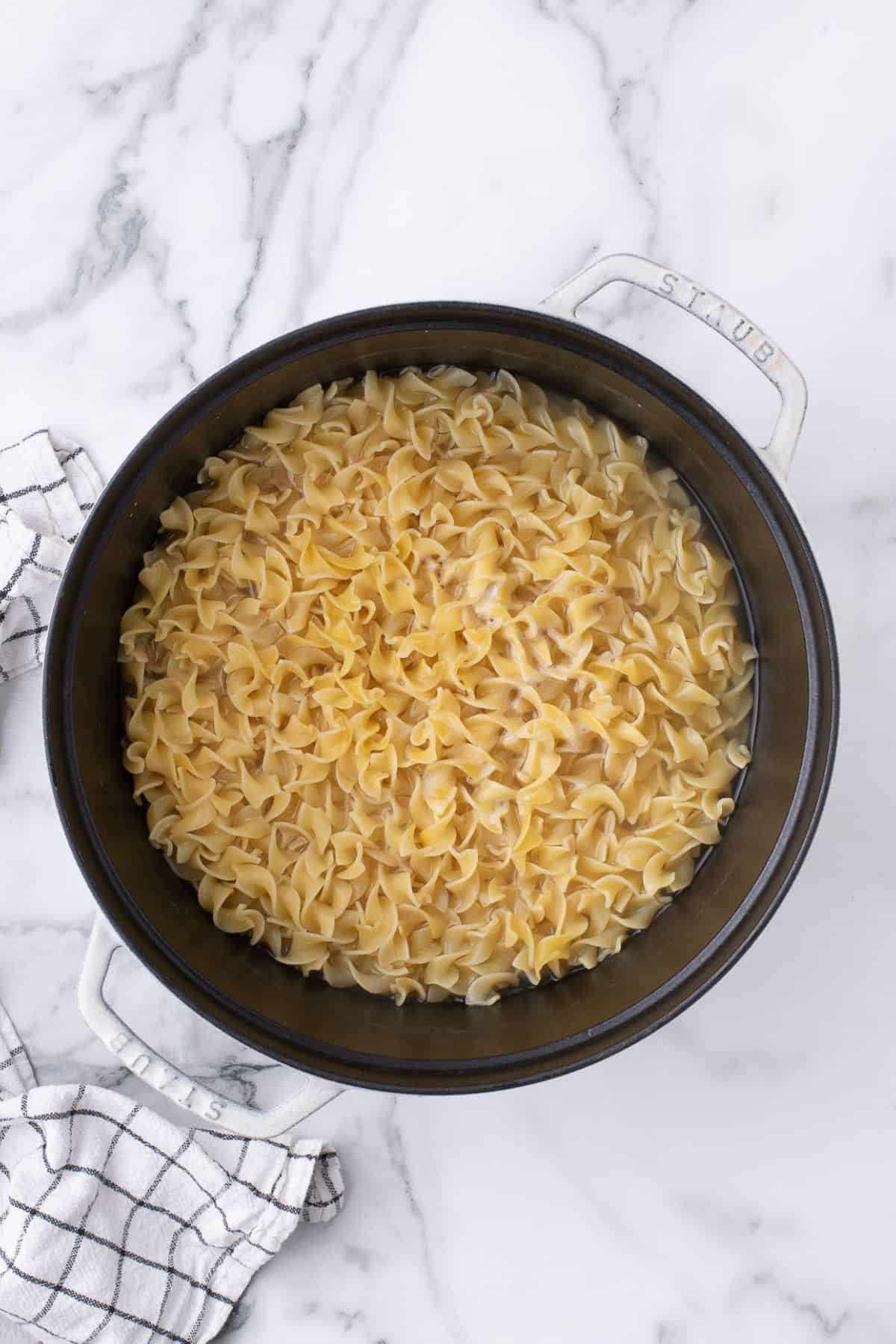 Cooked noodles in a cast iron pan.