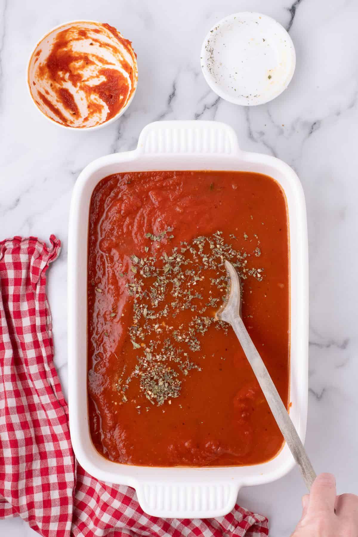 Seasonings added to the sauce in the white baking dish.