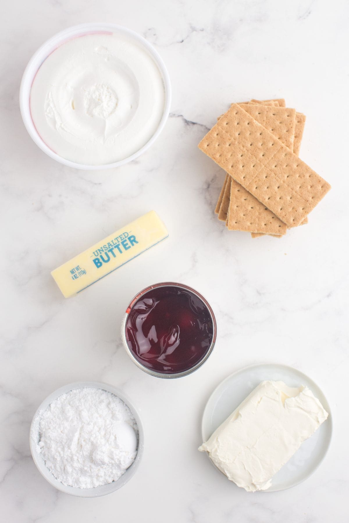 Ingredients for cherry delight: Cool Whip, graham crackers, butter, cherry pie filling, powdered sugar, and cream cheese.