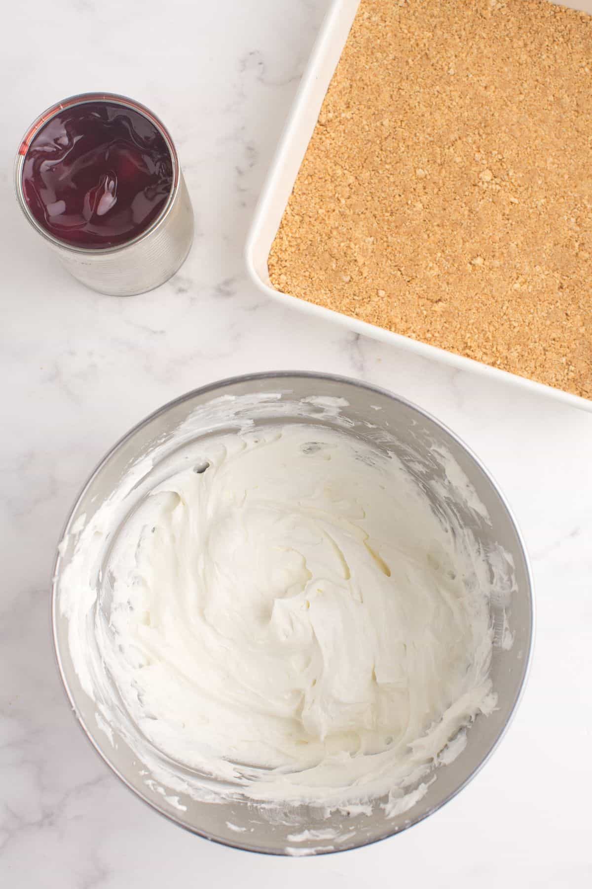 Whipped cream cheese and Cool Whip folded together in a mixing bowl.