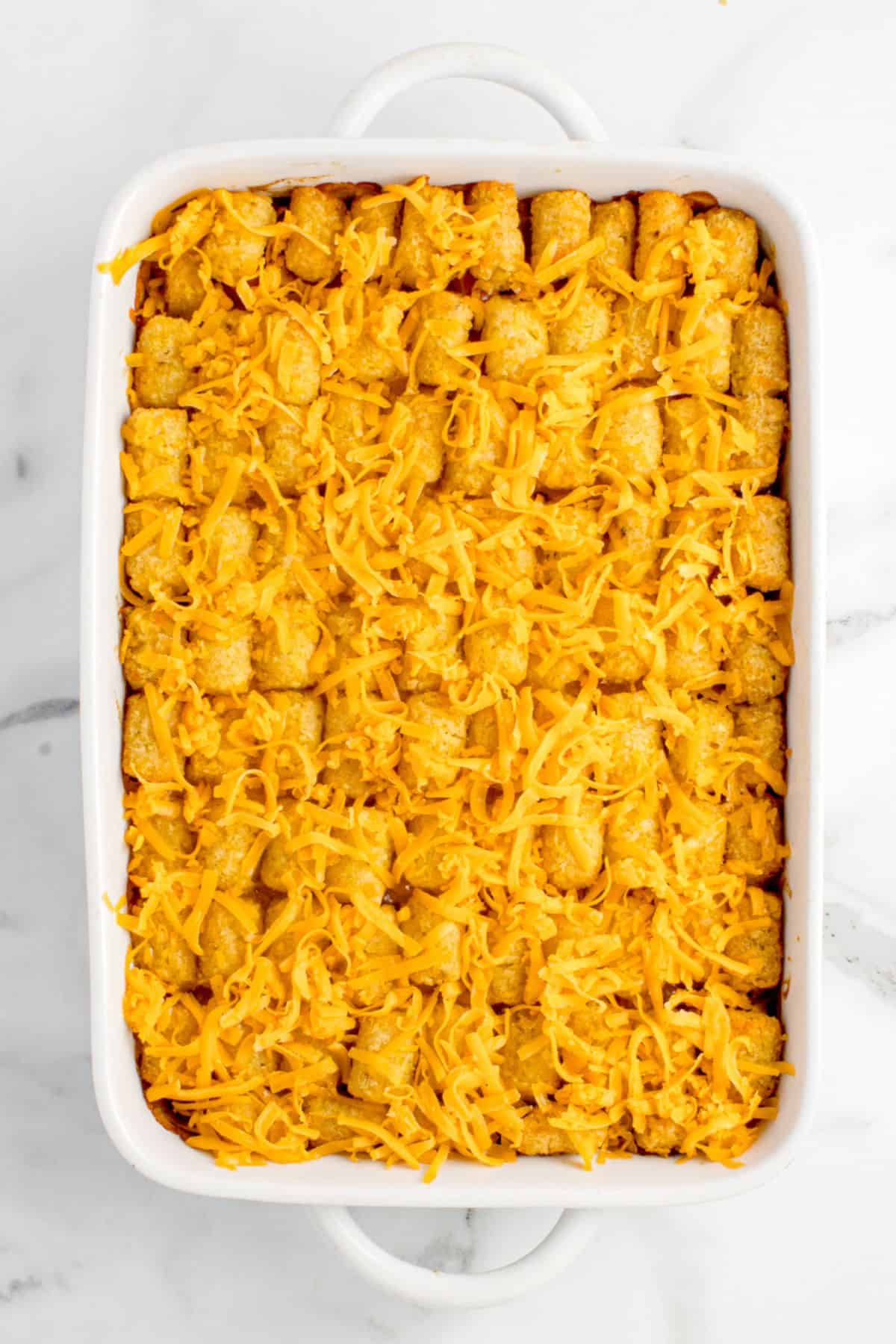 Baked casserole gets another layer of shredded cheese on top.