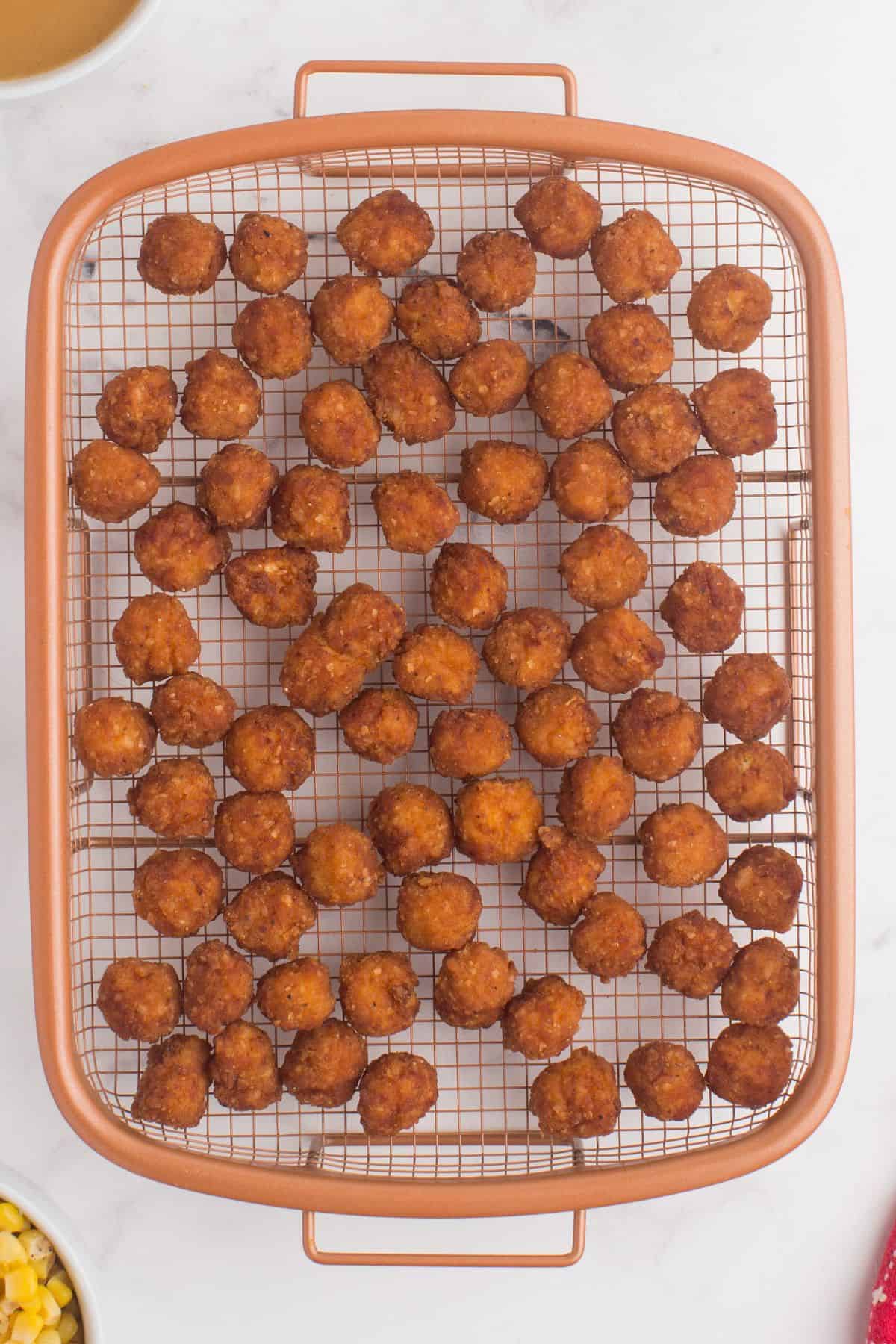 Popcorn chicken cooked on a mesh basket.