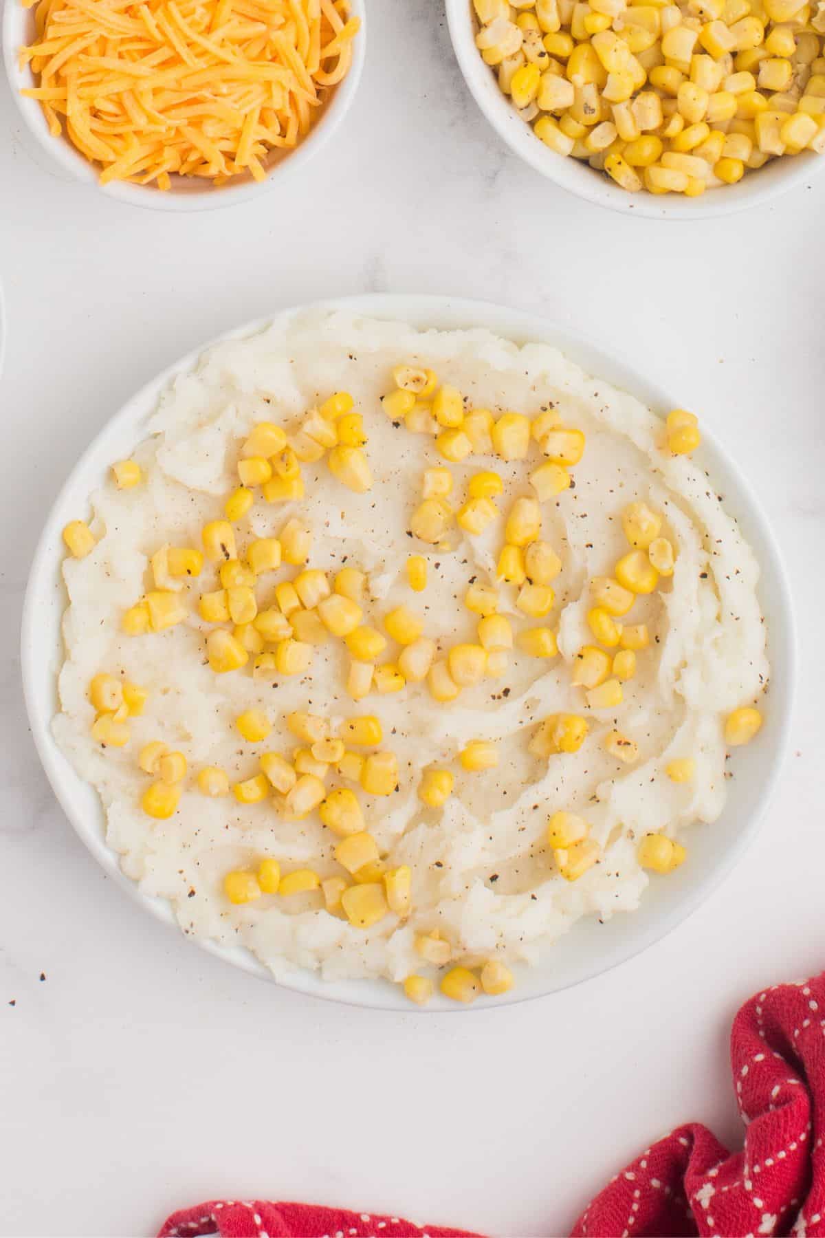 Mashed potatoes topped with corn in a bowl.